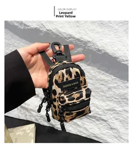 Macro detail of mini leopard print bag pendant with zipper and fashion label