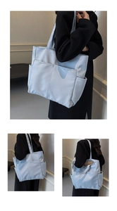 Détail d'un grand sac cabas bleu clair avec design multi-poches et texture en cuir PU
