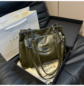 Dettaglio della borsa tote verde oliva in pelle plissettata con catena metallica elegante