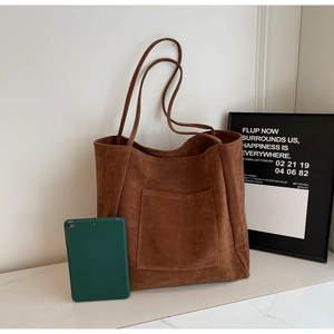 Detailed view of large dark brown suede tote bag showing texture and storage capacity