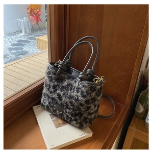 Dettaglio della borsa a secchiello peluche leopardata con manico in pelle marrone