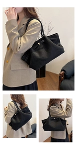 Dettaglio ravvicinato della borsa tote in pelle scamosciata con chiusura in metallo oro
