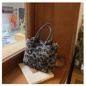 Dettaglio della borsa tote leopardata in ecopelliccia con manici in pelle sul davanzale