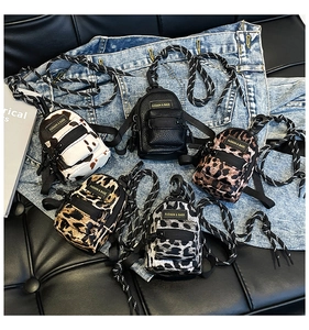 Mini backpack style coin purses in leopard and animal prints with lanyard on denim background