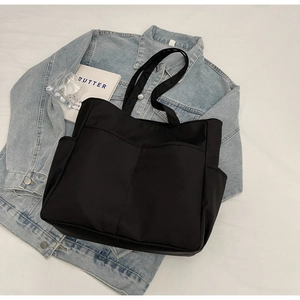 Détail du cabas en nylon noir avec design multi-poches et texture résistante à l'eau