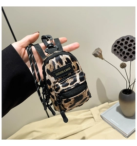 Close-up of mini leopard print crossbody bag with fashion label and black zipper detail