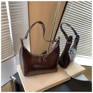 Dettaglio della borsa in pelle verniciata marrone scuro con finiture argento e tracolla regolabile