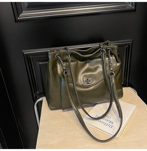 Dettaglio borsa tote in morbida pelle verde scuro con design a pieghe e chiusura a girello