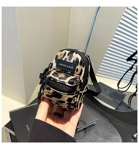Macro shot of mini leopard print crossbody bag showing zipper and fashion tag detail