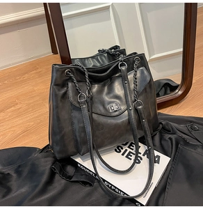 Dettaglio macro della borsa tote nera retrò con trama in pelle vintage e tracolla a catena
