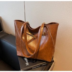 Detail view showing deep brown leather texture and decorative zippers on a vintage tote bag