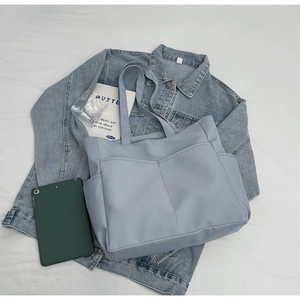 Vue détaillée du sac cabas en nylon bleu clair avec poches et bandoulière longue