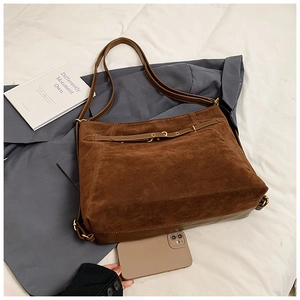 Close-up of vintage brown suede tote bag with belt detail and large storage capacity