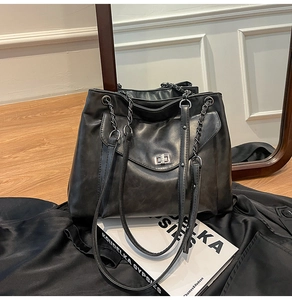 Dettaglio borsa tote in ecopelle nera che mostra la trama e la tracolla a catena
