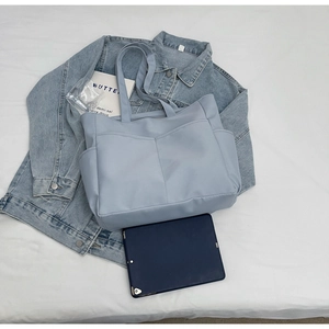 Vue détaillée de dessus du cabas en cuir bleu clair avec poche en V et tablette