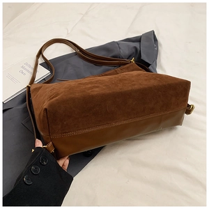 Detail of brown tote bag with contrast matte suede and glossy leather textures