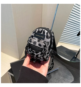 Detailed macro view of mini leopard print crossbody bag with fashion label and zipper