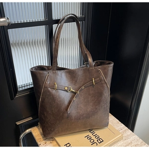 Detailed view of deep coffee vintage tote bag with gold buckles and side zippers
