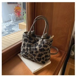 Détail du sac seau à imprimé léopard avec anses en cuir et design noué sur magazine