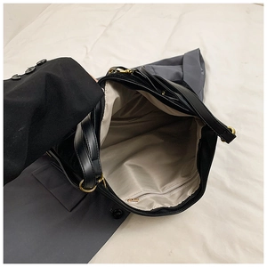 Top-down view of black tote bag interior with gray fabric lining and zipper pocket