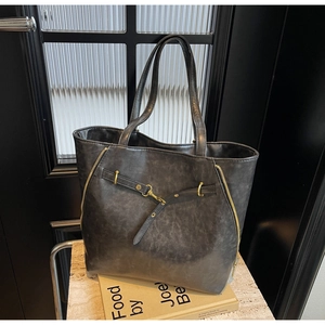 Detailed macro view of dark grey vintage tote bag with gold zippers and metal hardware