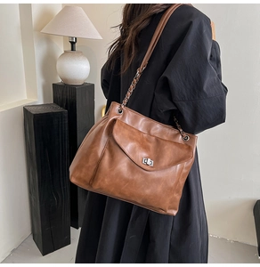 Dettaglio della borsa tote marrone vintage con tasca a girello e tracolla a catena chic