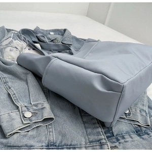 Gros plan du sac cabas en nylon bleu clair avec poche extérieure sur une veste
