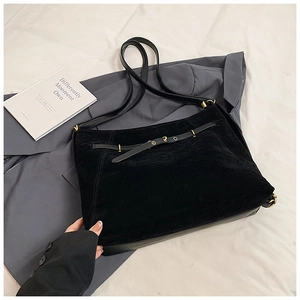 Detail of black suede tote bag with leather belt decoration and golden hardware