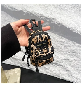 Close-up of mini leopard print charm bag with grain leather texture and black hook