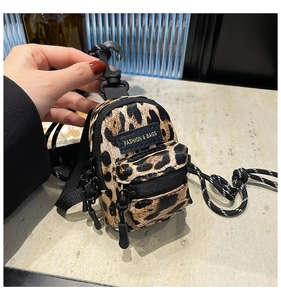 Mini leopard print crossbody bag detail showing logo tag and black nylon strap