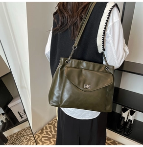 Dettaglio della borsa tote in ecopelle verde oliva con catena in metallo e chiusura a vite