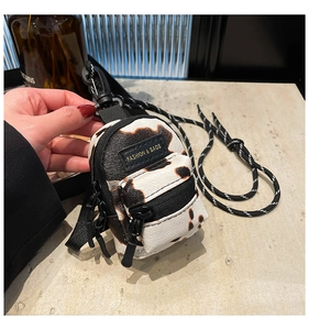Detail of a mini cow print crossbody bag for girls with high-quality woven lanyard