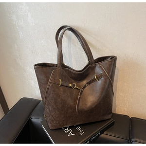Detail of vintage brown tote bag with gold zippers and buckle on leather texture