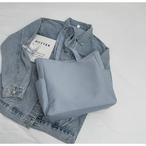 Vue de dessus d'un sac cabas en nylon bleu brume avec poches sur tissu doux