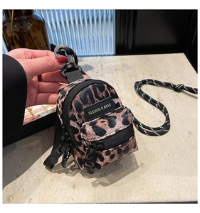 Close-up of leopard print mini bag showing the fashion label and lanyard details