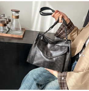 Dettaglio borsa tote grigia vintage con chiusura girevole retrò e tracolla a catena