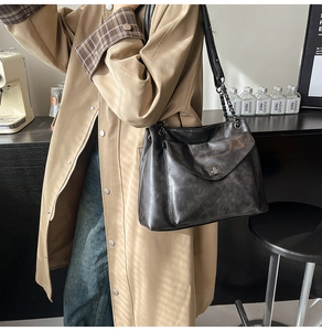 Dettaglio di borsa tote nera vintage con chiusura a scatto e tracolla a catena