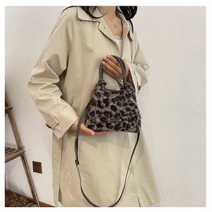 Dettaglio della borsa a secchiello in finta pelliccia leopardata con manici in pelle