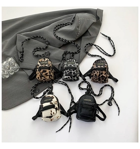 Detail view of five mini cross-body pouches in leopard, cow print and black leather textures