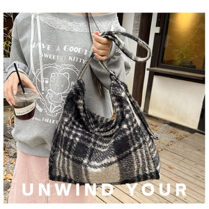 Detail shot of the large capacity hobo bag in a black and grey checkered plush fabric