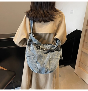 Rückansicht einer großen hellblauen Denim Umhängetasche mit Lederriemen an einem Model