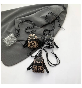 Detailed view of mini leopard print crossbody pouches in yellow, grey, and dark brown colors