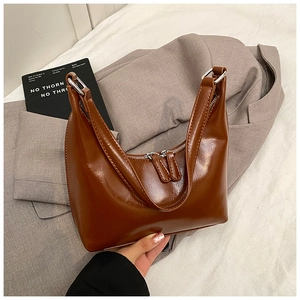 Dettaglio della borsa in pelle marrone lucida con cerniere metalliche in stile vintage