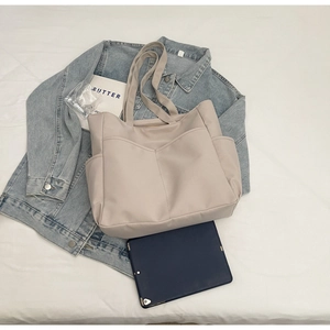 Grand sac cabas beige présenté à côté d'une tablette pour illustrer sa grande capacité