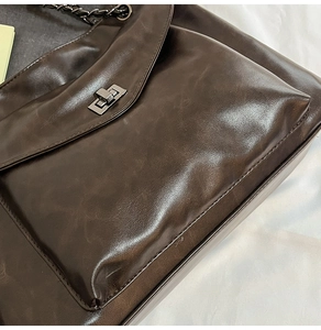 Dettaglio ravvicinato della borsa in pelle PU marrone scuro con chiusura a rotazione