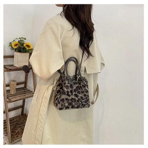 Donna che indossa una borsa a secchiello leopardata in ecopelliccia con un trench