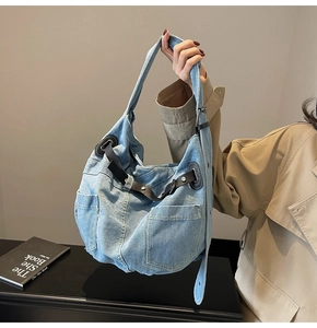 Nahaufnahme der gewaschenen blauen Denim-Tasche mit Lederriemen und silbernen Nieten