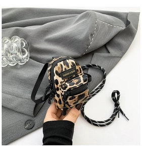 Mini leopard print crossbody bag with black zipper detail and woven shoulder strap