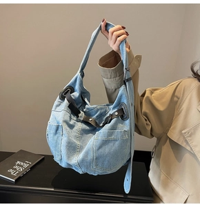 Makro-Detail einer großen Denim-Einkaufstasche mit Lederbesatz und blauem Stoffmuster