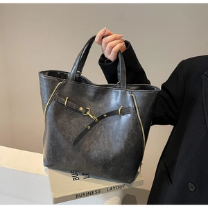 Close-up of vintage large tote bag with gold zippers and textured leather details